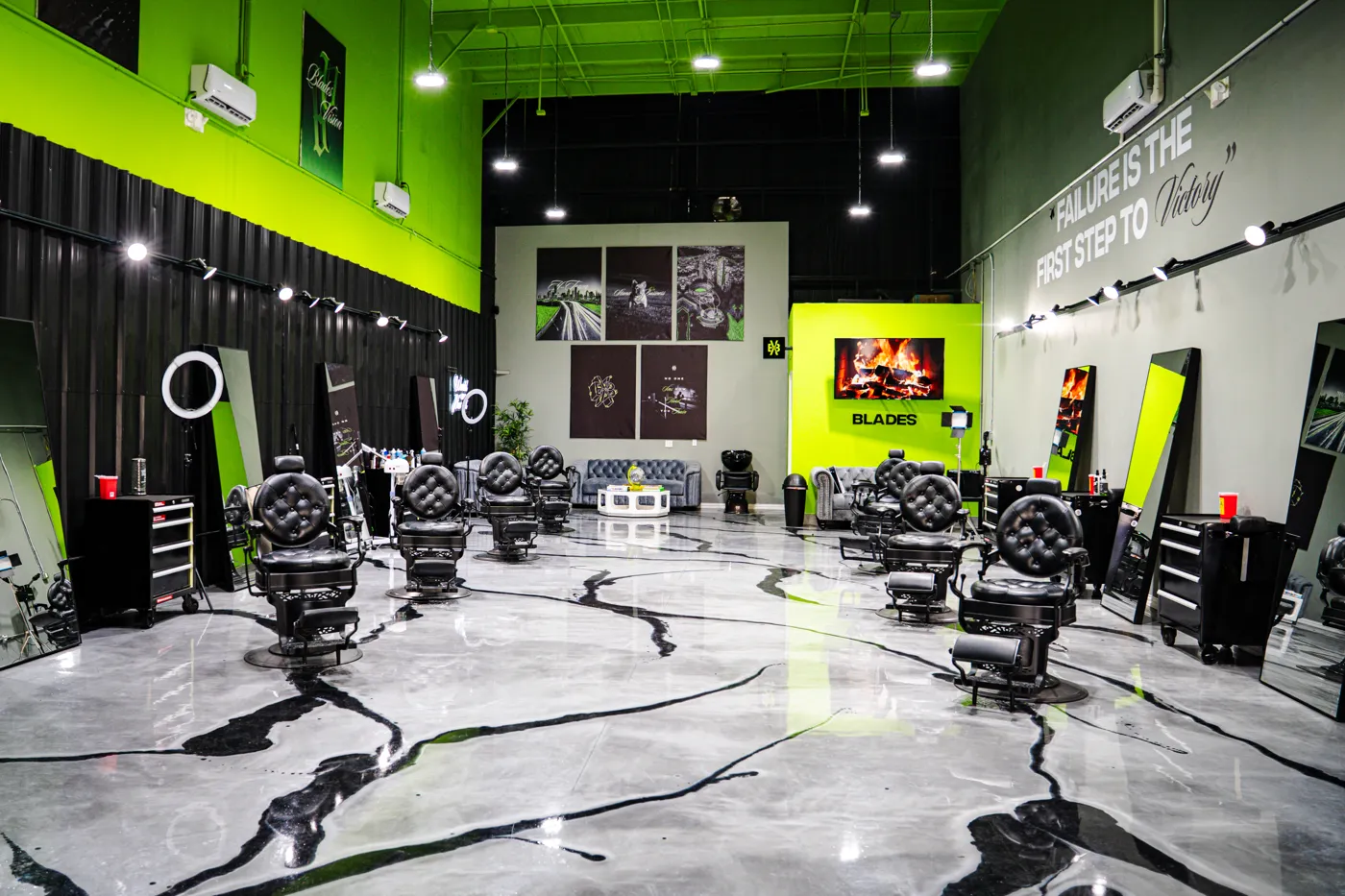 Interior de una barbería Blades Vision — sillas de barbero y paredes verdes. Reserva tu silla