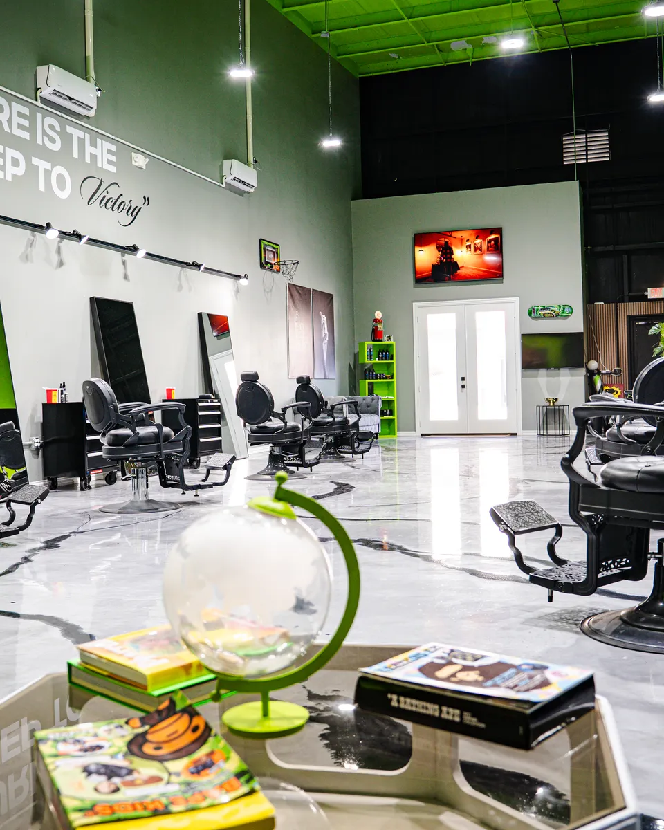 Interior de una barbería Blades Vision — sillas de barbero y paredes verdes